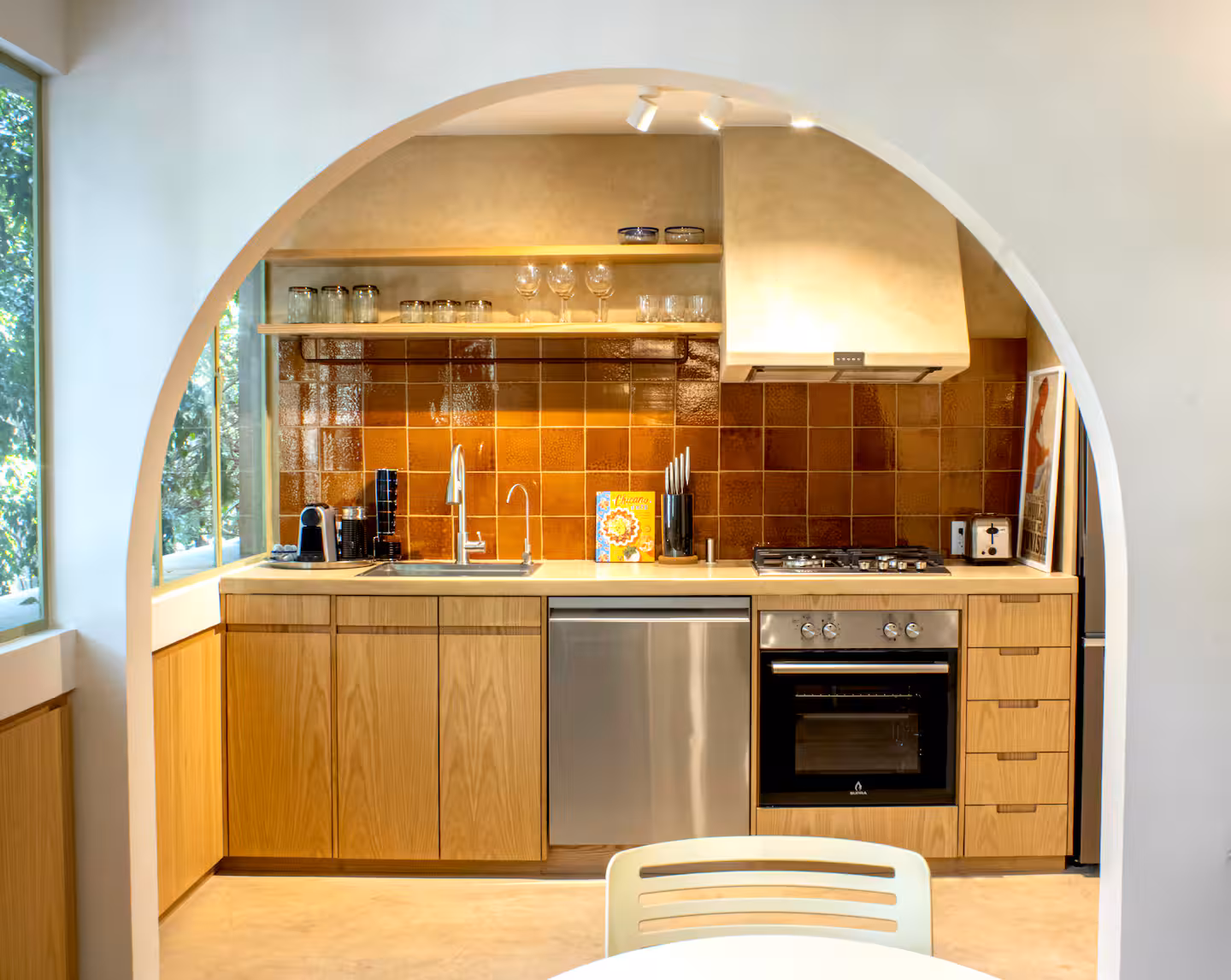 Kitchen with terracotta tile arch and full appliances